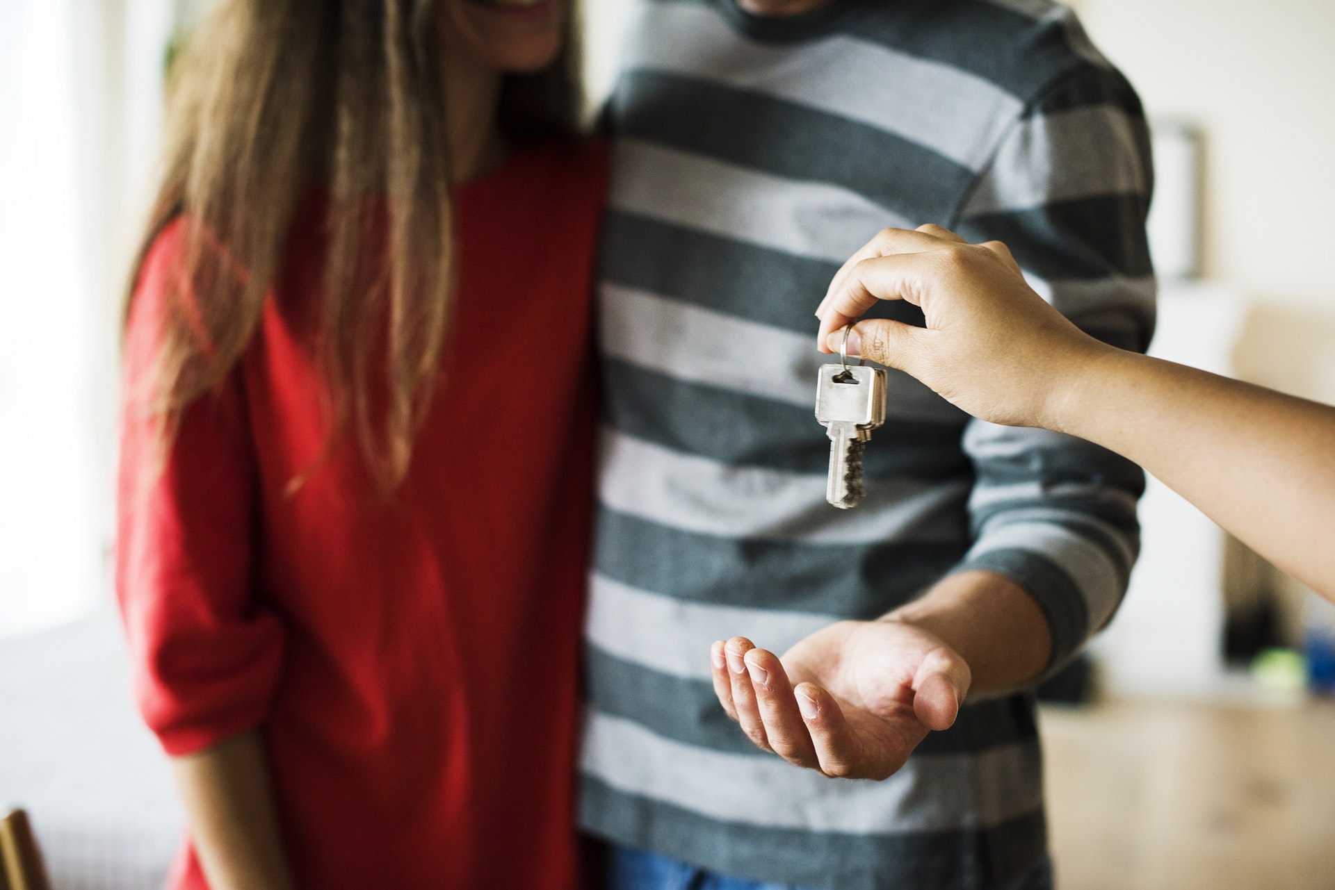 Decorative image of person handing over keys.
